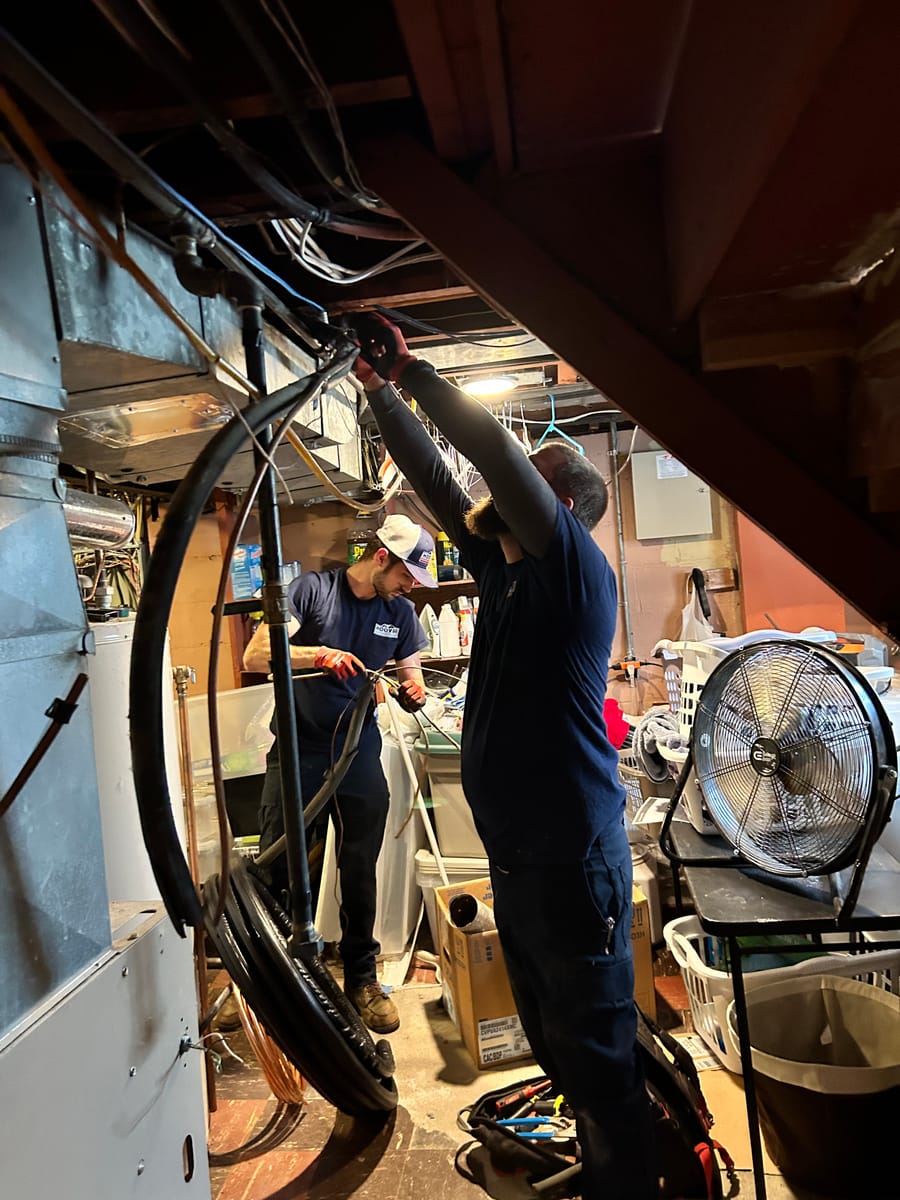 Plumbers conducting air conditioning maintenance