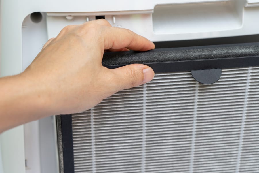 hand replacing HEPA air filter
