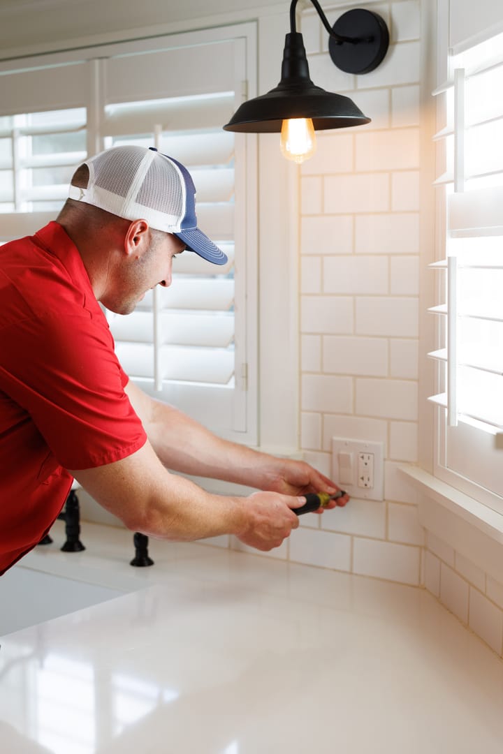 Technician installing outlet next to sink