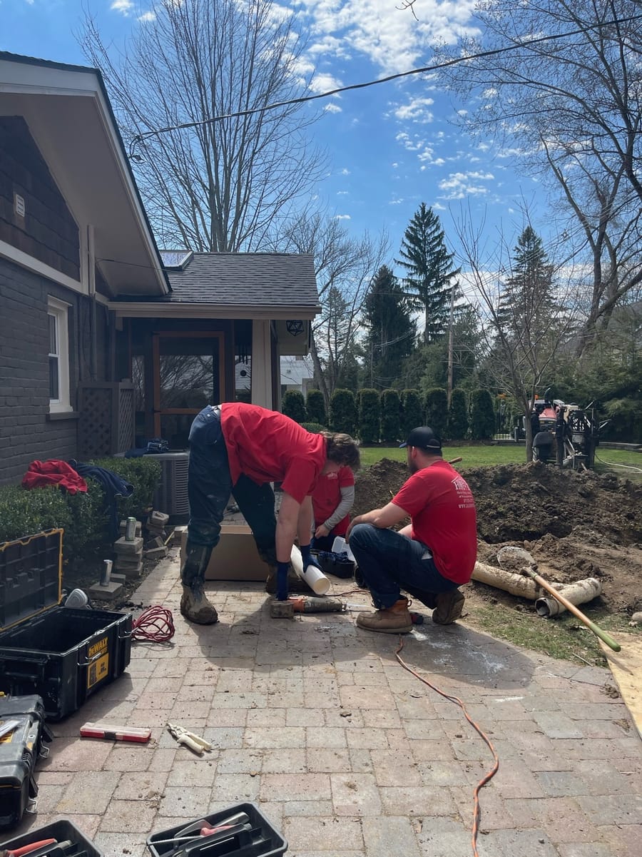 Two men digging for sewer service
