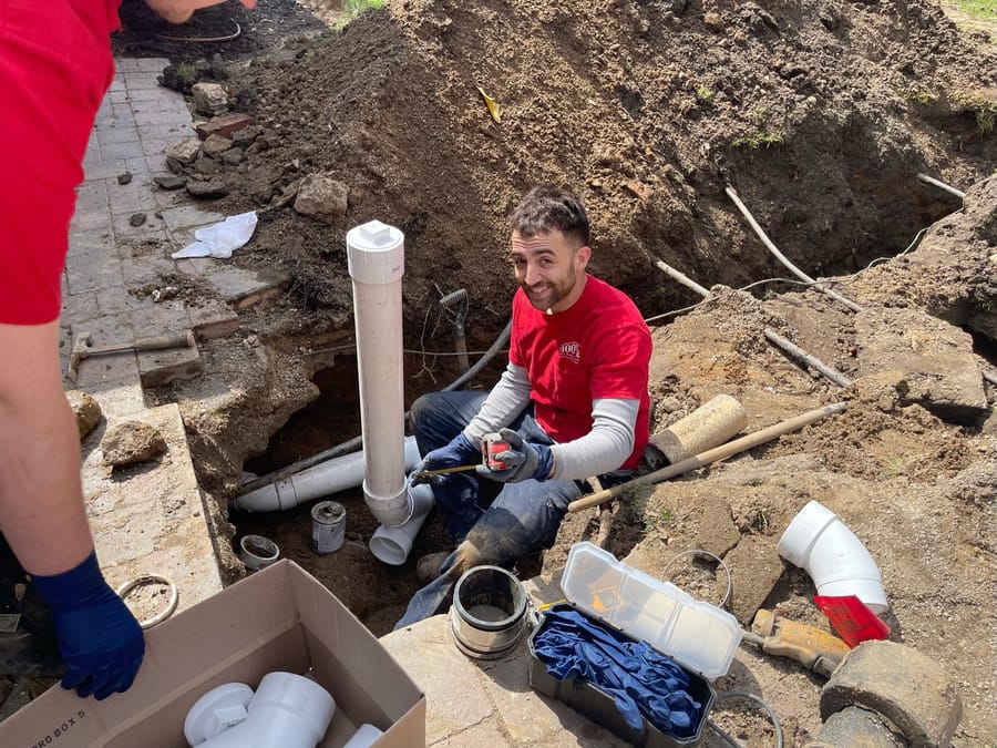 Man digging in the ground for pipe lining services
