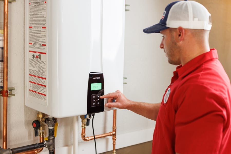 Technician adjusting tankless water heater