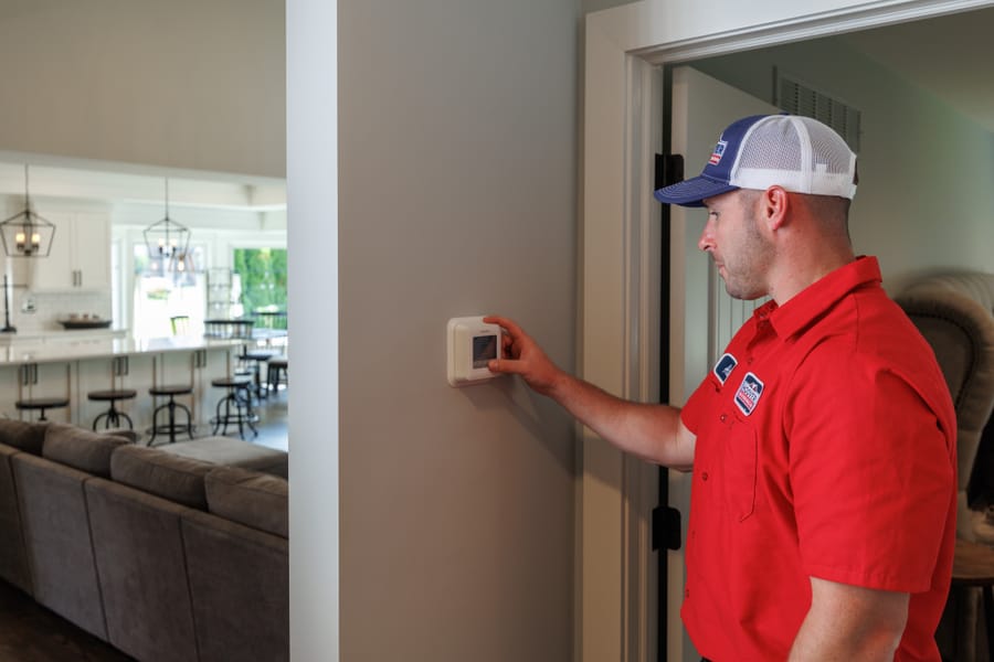Technician working on a home's thermostat